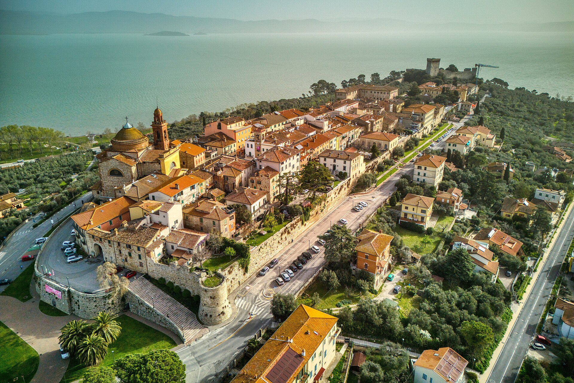 Veduta aerea di Castiglione del Lago sul Trasimeno, con il borgo murato, la rocca e il lago sullo sfondo